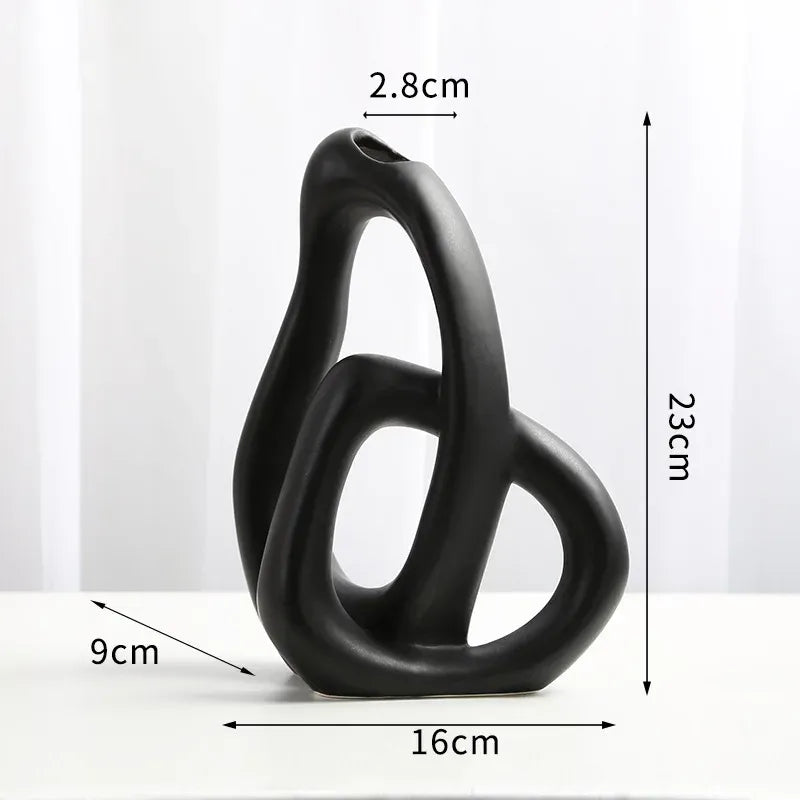 Black abstract sculpture with measurements on a white background