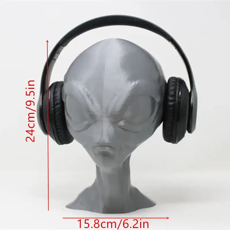 Black headphones on a gray alien head with measurements indicated
