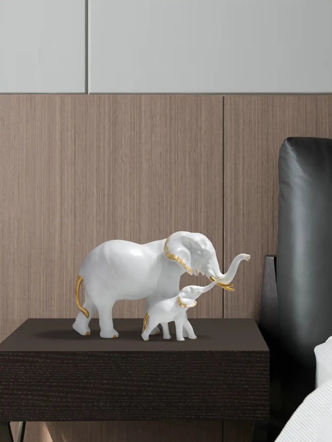 Decorative white elephant figurine with gold accents on a wooden surface.