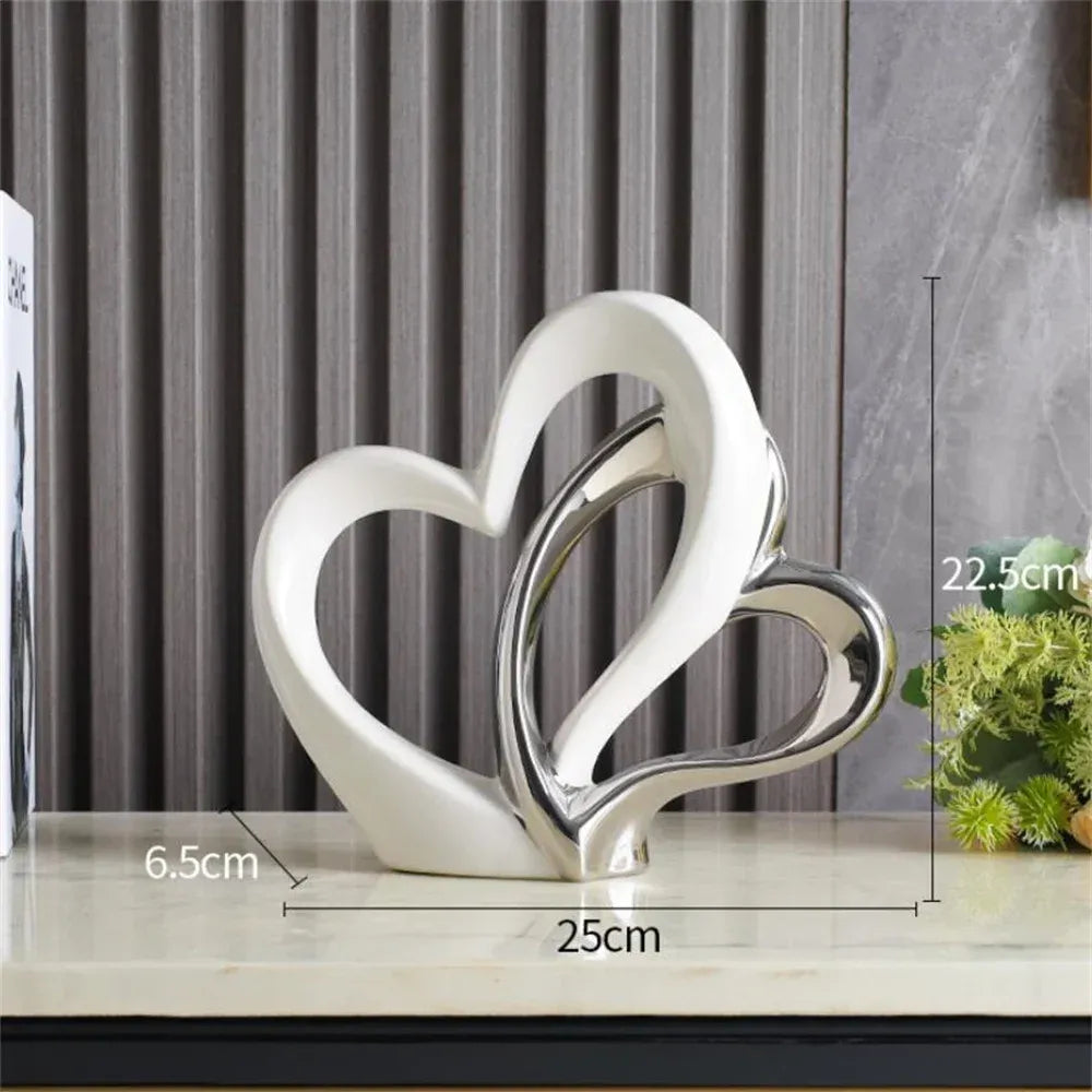 Decorative sculpture of two interlocking hearts on a surface with measurements indicated.