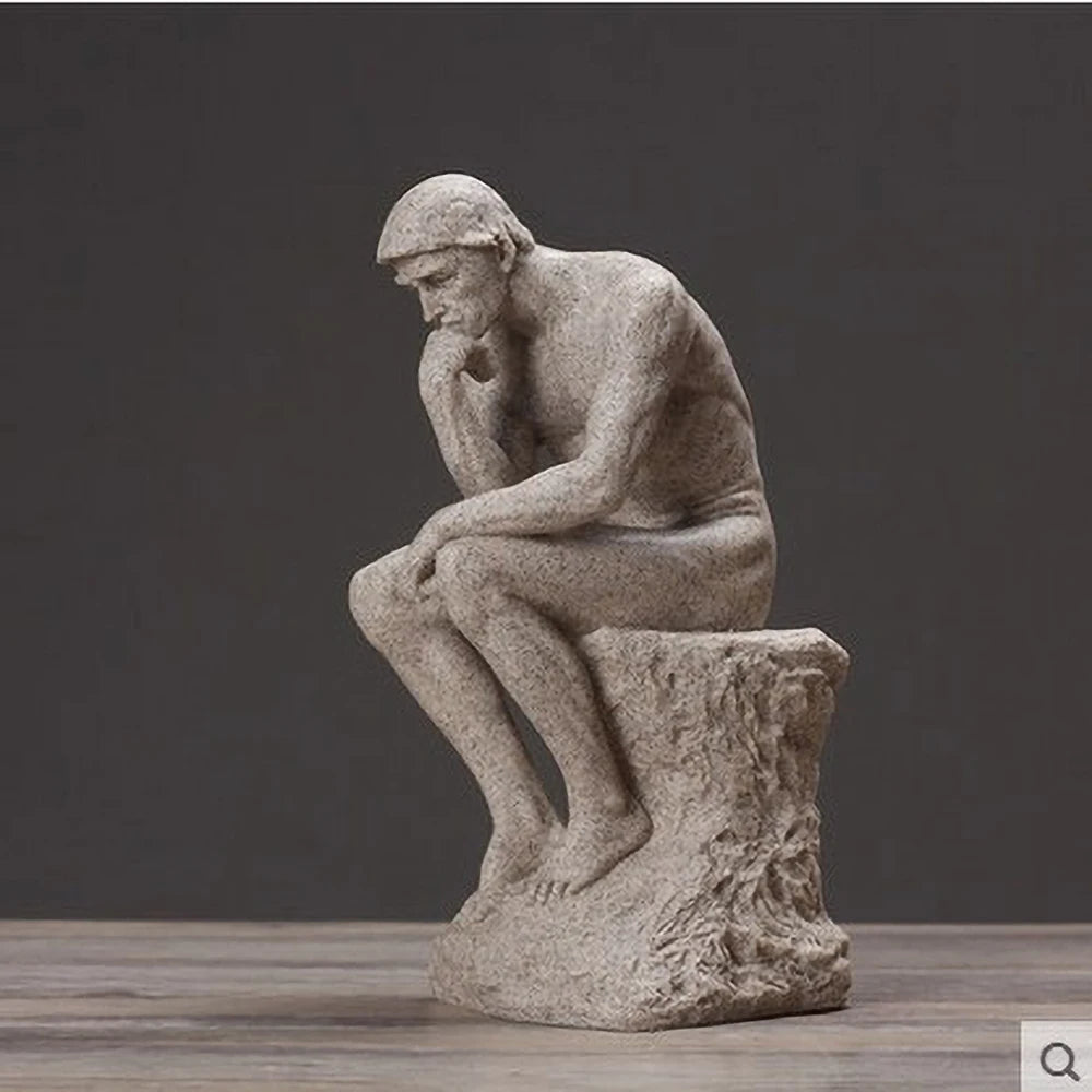 Statue of a thinker sitting on a pedestal against a dark background