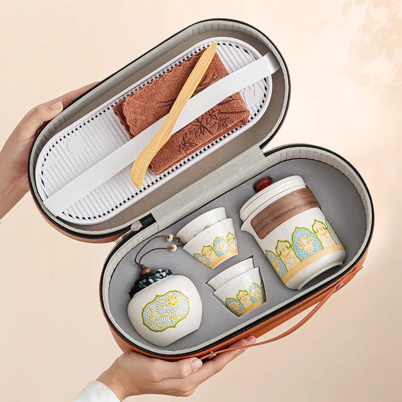 Tea set in a carrying case held by a hand on a beige background