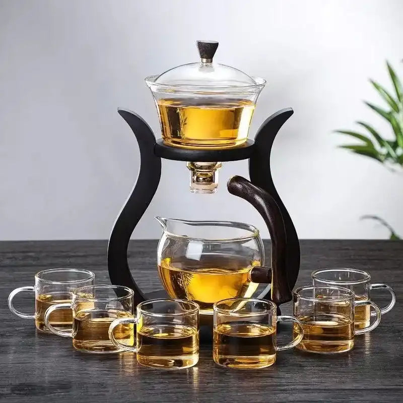 Tea set with glass teapot and cups on a wooden table