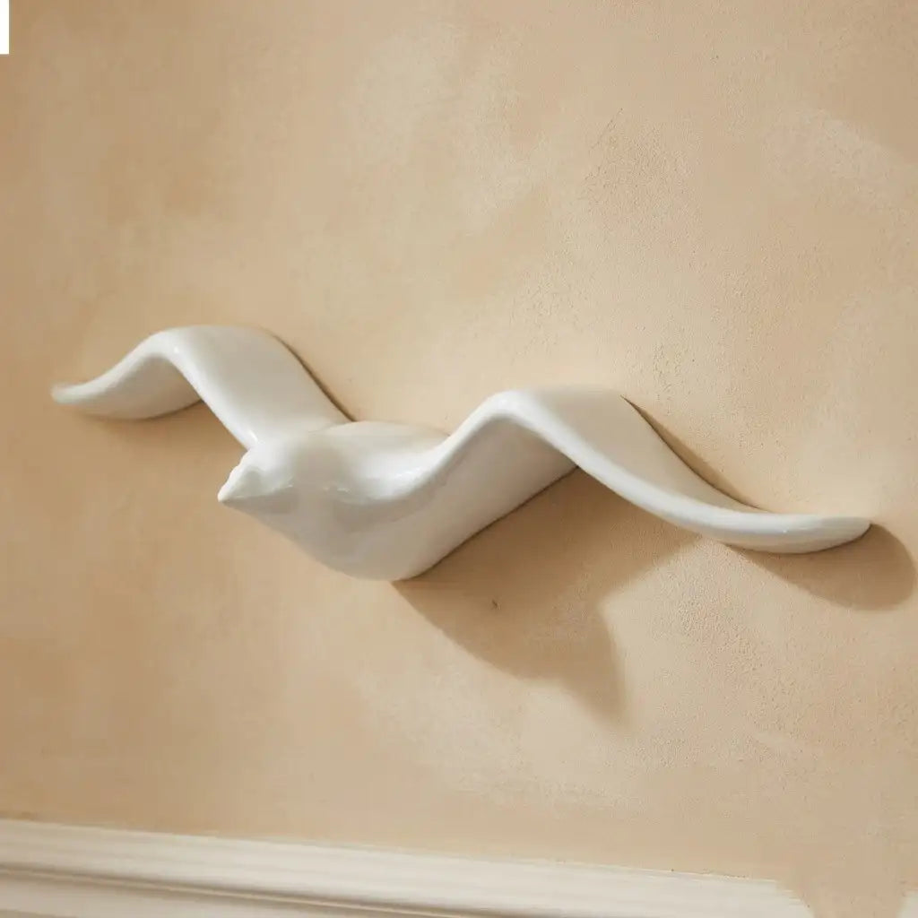 White ceramic Bird-shaped object on a beige background