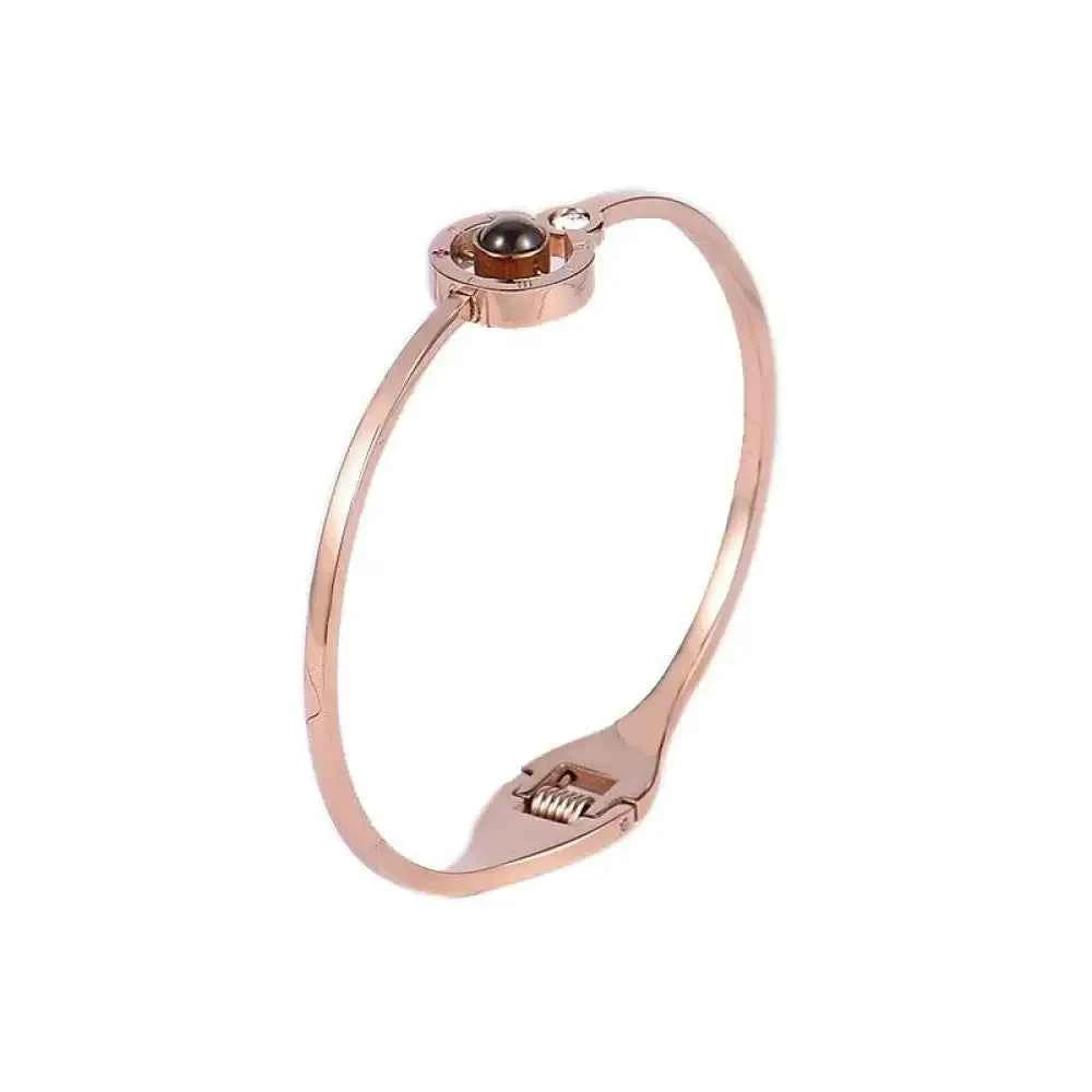 Rose gold bangle-style lover bracelet with black pearl skull glass charm