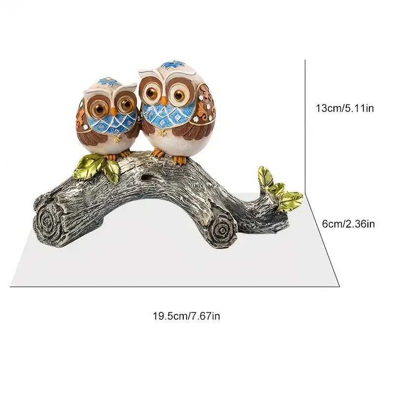 Two owl figurines on a branch with measurements indicated