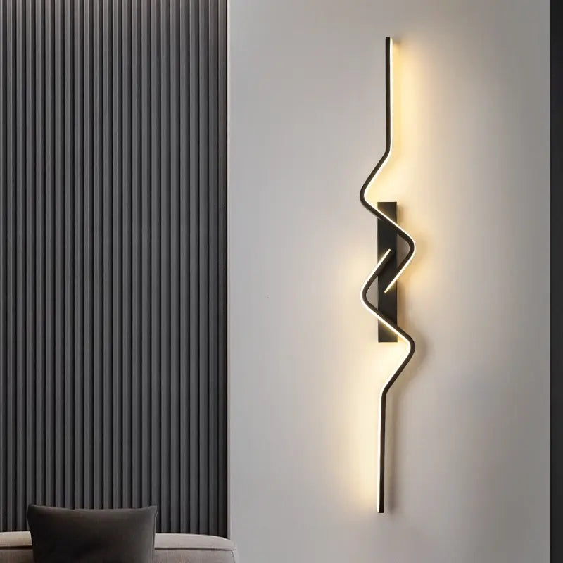 Modern wall sconce with a wavy design on a neutral wall.