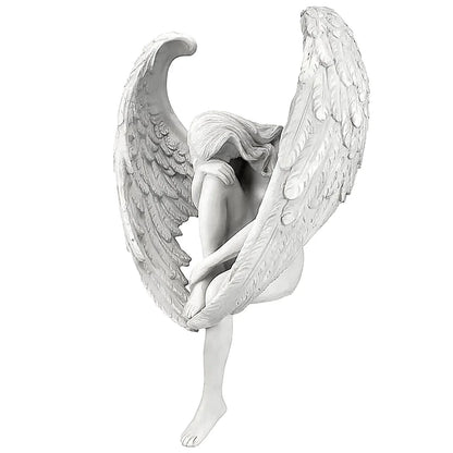 White angel figurine with detailed wings on a white background