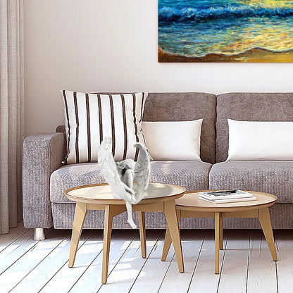 Gray sofa with striped pillow and white cushions, wooden coffee table, and painting of a beach scene.