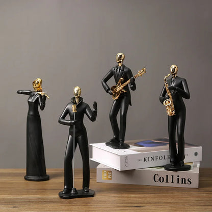 Black and gold figurines of musicians on books against a gray background