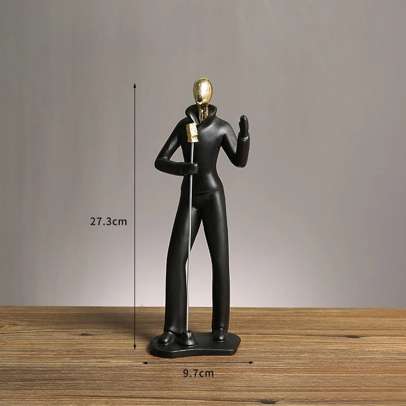 Black and gold sculpture on a wooden surface with measurements indicated