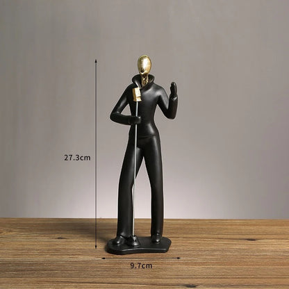 Black and gold sculpture on a wooden surface with measurements indicated