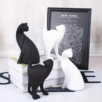 Black and white cat figurines on a surface with a map of New York in the background.