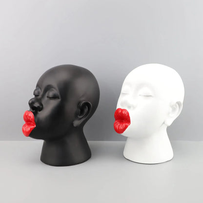 Black and white mannequin heads with red lips on a gray background