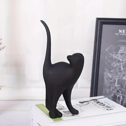 Black cat figurine on a surface with a blurred background