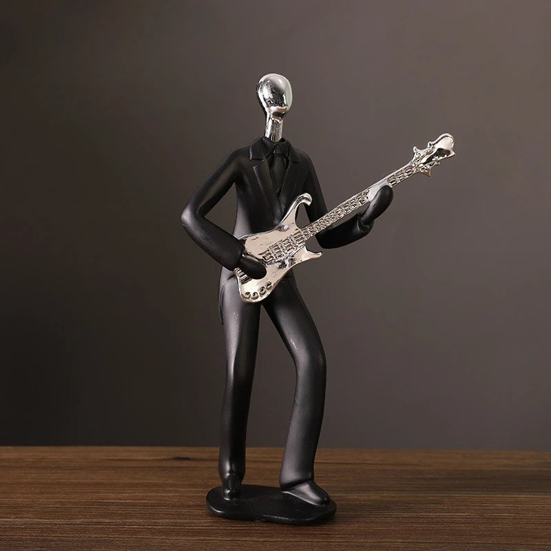 Decorative figure of a person playing an electric guitar on a wooden surface with a dark background