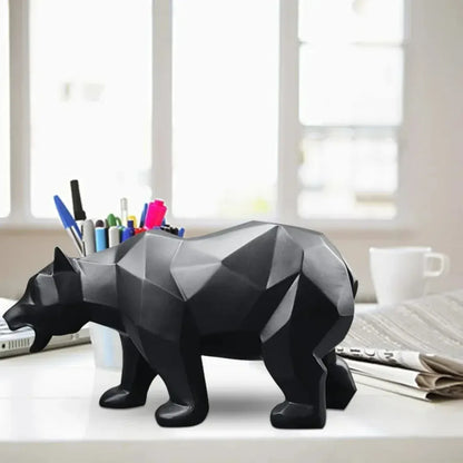 Black geometric bear on a desk with office supplies.