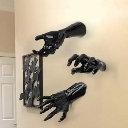 Black hand-shaped hooks on a beige wall
