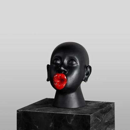 Black mannequin head with red lips on a gray background