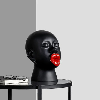 Black mannequin head with red lips on a gray background