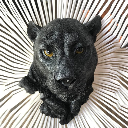 Black panther sculpture on a decorative wall piece with a geometric pattern