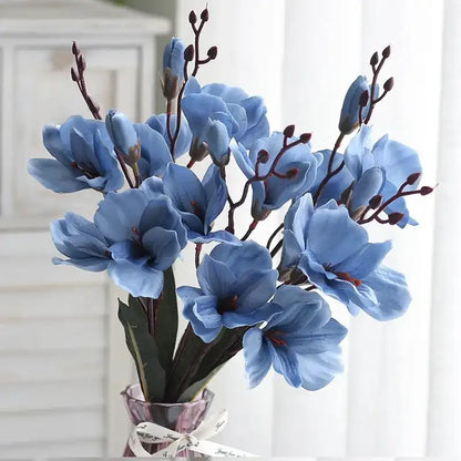 Bouquet of blue flowers in a clear vase against a white background