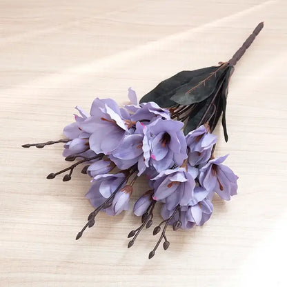 Bouquet of purple flowers with green leaves on a beige textured background