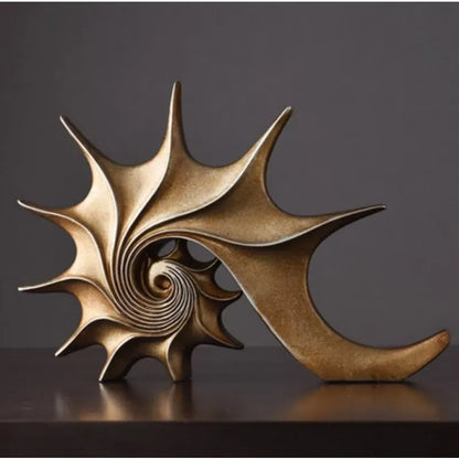 Bronze shell sculpture on a dark surface with a dark background