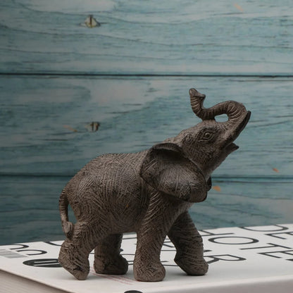 Bronze elephant figurine on a wooden surface with a blurred background