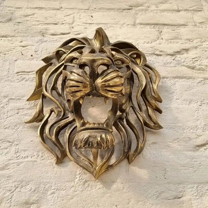 Bronze lion head sculpture on a textured stone wall