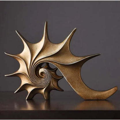 Bronze shell sculpture on a dark surface with a dark background