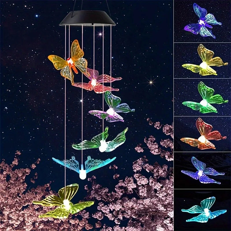 Butterfly-shaped solar light hanging against a dark sky with cherry blossoms.