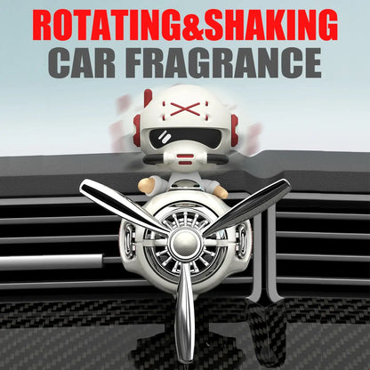 Car air freshener with a robot design on a car vent, featuring text 'Rotating & Shaking Car Fragrance'.