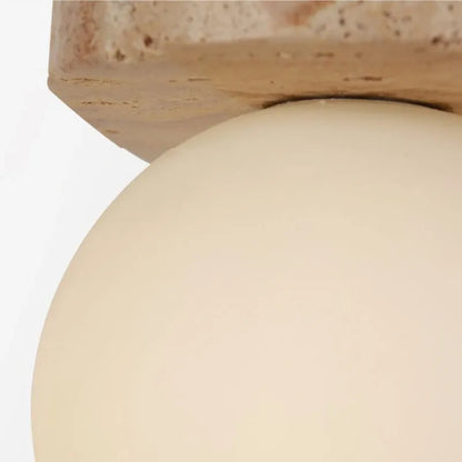 Close-up of a beige spherical object with a wooden base on a white background