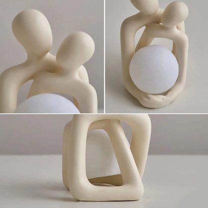 Collage of a beige ceramic sculpture of two abstract figures holding a sphere on a light gray background.