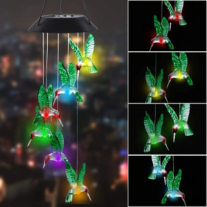 Colorful hummingbird-shaped solar mobile with LED lights on a dark background.