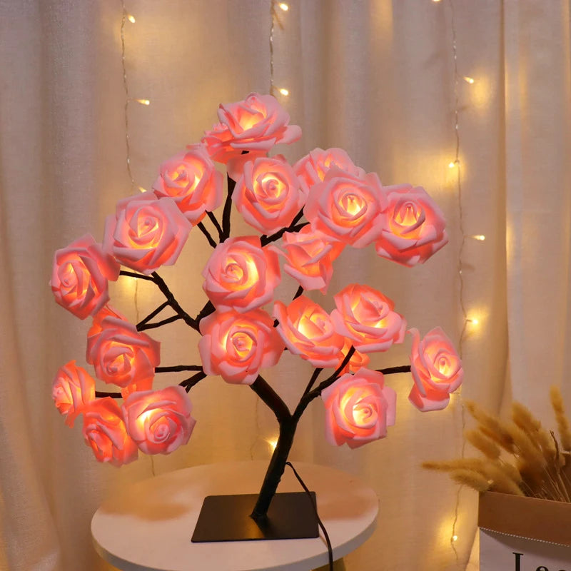 Decorative LED rose tree on a small round table with warm lighting against a neutral background.