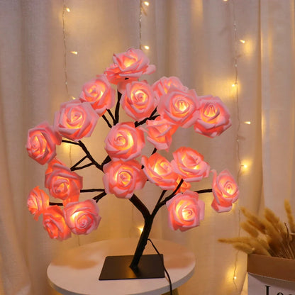 Decorative LED rose tree on a small round table with warm lighting against a neutral background.