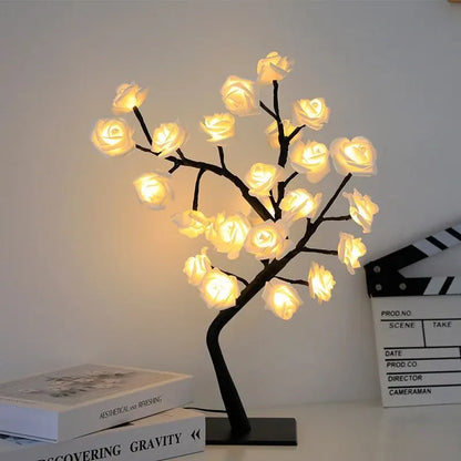 Decorative LED tree with glowing flowers on a white surface.