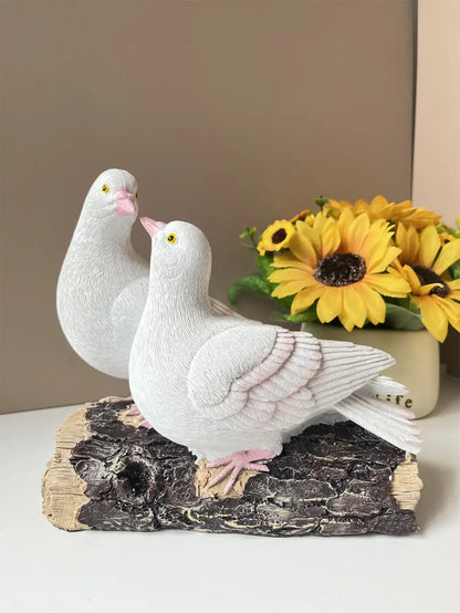 Decorative figurine of two white doves on a log with sunflowers in the background.