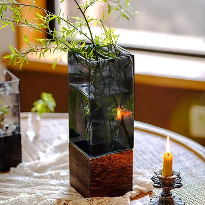 Decorative vase with green branches on a table with a blurred background