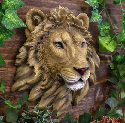 Decorative lion head wall art with green leaves in the background