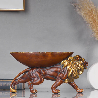 Decorative lion sculpture with a bowl on its back against a gray wall.