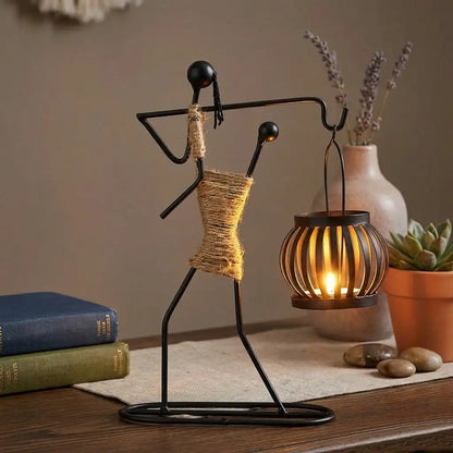Decorative metal figure with a lantern on a wooden surface with books and plants.