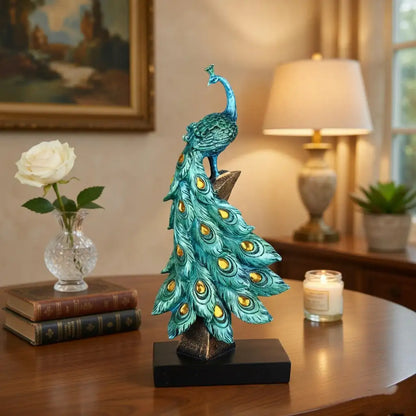 Decorative peacock statue on a table with books, candle, and lamp in the background
