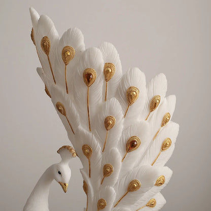 Decorative peacock feather sculpture with gold accents on a plain background