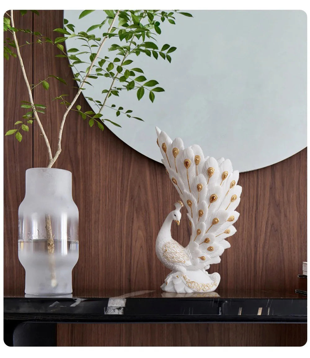 Decorative peacock sculpture on a table with a vase and plant in the background.