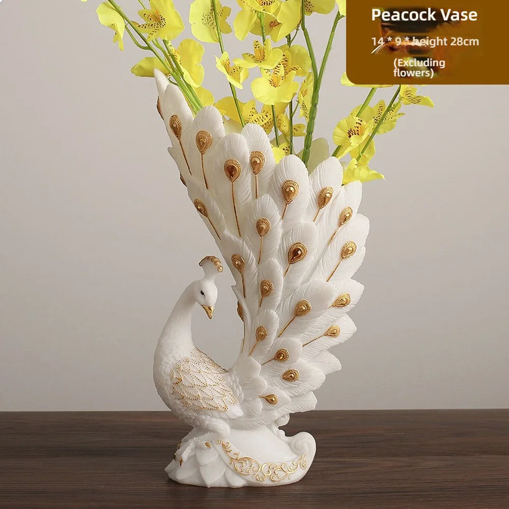 Peacock-shaped vase with decorative peacock feathers and a white swan base, containing yellow flowers on a wooden surface.