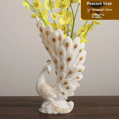 Peacock-shaped vase with decorative peacock feathers and a white swan base, containing yellow flowers on a wooden surface.