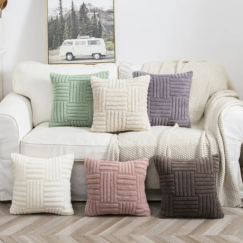 Decorative pillows on a sofa with a mountain landscape painting in the background